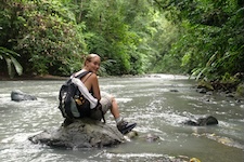 Randonneuse assise sur une pierre dans une rivière au parc Corcovado