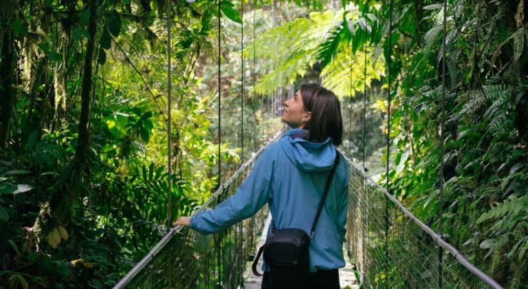 Femme observant la jungle sur un pont suspendu au Costa Rica
